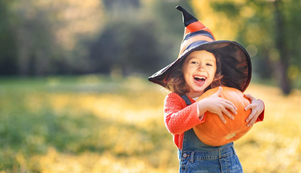 Girl holding a pumpkin at a pumpkin picking field